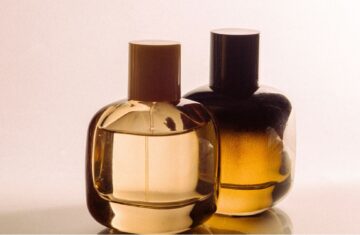 Dwa flakony damskich perfum na jasno różowym tle